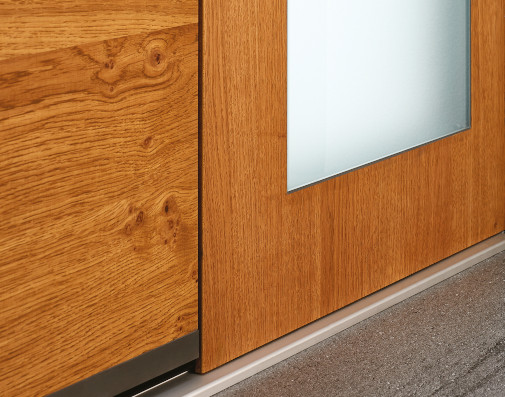 Nahaufnahme einer Aluminium-Haustür mit Holzdekor-Oberfläche und Glaseinsatz